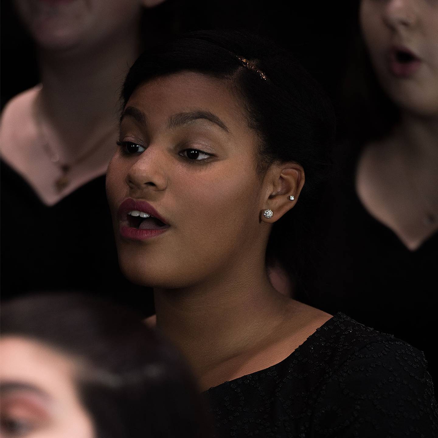 Close up of a woman singing in a choir.